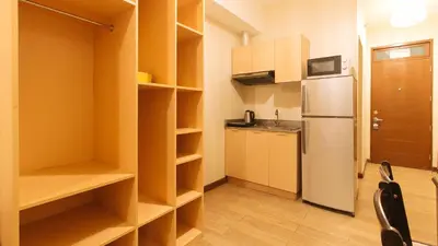 a small kitchen with a refrigerator and shelves in it at RedDoorz Plus @ Cuarto Verde Staycation in Manila