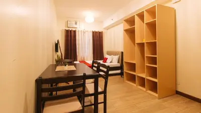 a small room with a desk and a room with a couch at RedDoorz Plus @ Cuarto Verde Staycation in Manila