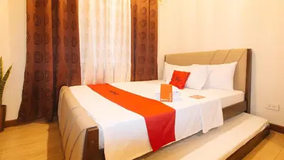 a hotel room with a bed with a book on it at RedDoorz Plus @ Cuarto Verde Staycation in Manila