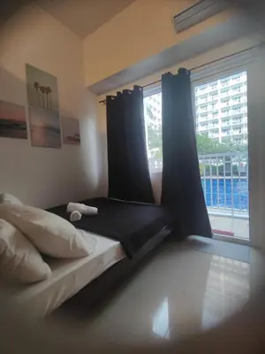 a bedroom with a bed with curtains and a window at Sweet Stays 888 in Manila