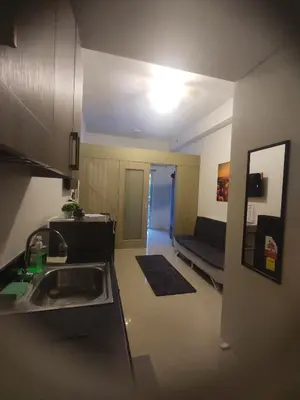 a kitchen and living room with a sink and a couch at Sweet Stays 888 in Manila