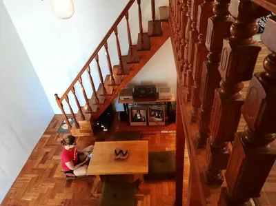 a young child sitting on the floor under a staircase at Omotenashi House of Santa Rosa City Laguna in Caingin
