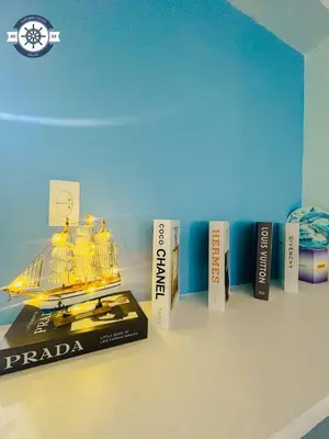 a book shelf with a model of a boat on it at Ocean theme Navy Blue Deluxe Suite with PS4 and Balcony overlooking Manila Bay and Manila Zoo plus near Manila Yacht Club and Star City in Manila