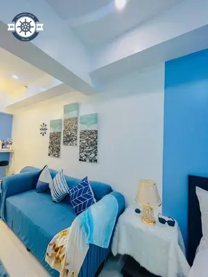 a living room with a blue couch and a table at Ocean theme Navy Blue Deluxe Suite with PS4 and Balcony overlooking Manila Bay and Manila Zoo plus near Manila Yacht Club and Star City in Manila