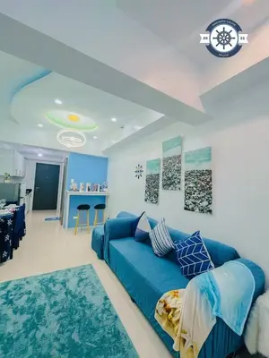 a living room with a blue couch and a kitchen at Ocean theme Navy Blue Deluxe Suite with PS4 and Balcony overlooking Manila Bay and Manila Zoo plus near Manila Yacht Club and Star City in Manila