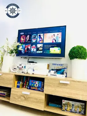 a tv sitting on top of a wooden entertainment center at Ocean theme Navy Blue Deluxe Suite with PS4 and Balcony overlooking Manila Bay and Manila Zoo plus near Manila Yacht Club and Star City in Manila