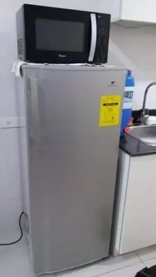 a microwave on top of a refrigerator in a kitchen at Sea Residences Homey Condo by DNJ in Manila