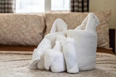 a pile of towels sitting on top of a bed at Raya P09 - Airport-Side Penthouse in Manila