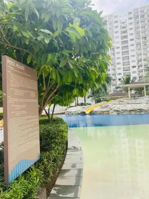 a sign next to a swimming pool in a city at Dtravellers Home 2 at SHORE 1 TOWER C (Near MOA) in Manila