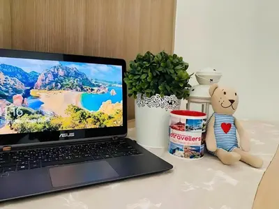 a laptop computer sitting on a desk with a teddy bear at Dtravellers Home 2 at SHORE 1 TOWER C (Near MOA) in Manila