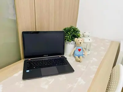 a laptop computer sitting on a table with a teddy bear at Dtravellers Home 2 at SHORE 1 TOWER C (Near MOA) in Manila