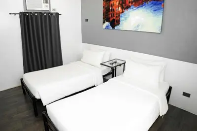 two beds sitting next to each other in a room at mySTAY Hotel BGC North in Manila