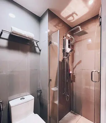 a bathroom with a shower and a toilet at Makati Cosy Home l Couples Families l 500Mbps Wifi in Manila
