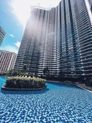a large building with a large pool in front of it at Makati Cosy Home l Couples Families l 500Mbps Wifi in Manila