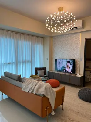 a living room with a couch and a flat screen tv at 1BRFacing ManilaBay SunsetNear Okada Solaire 1Park in Manila
