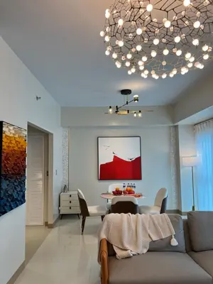 a living room with a couch and a chandelier at 1BRFacing ManilaBay SunsetNear Okada Solaire 1Park in Manila
