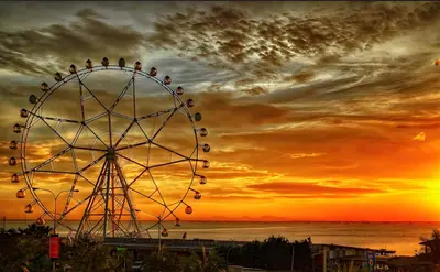 a ferris wheel with a sunset in the background at 1BRFacing ManilaBay SunsetNear Okada Solaire 1Park in Manila