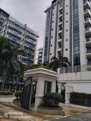 a building in front of two tall buildings at Rqui CondoTel Near Airport in Manila