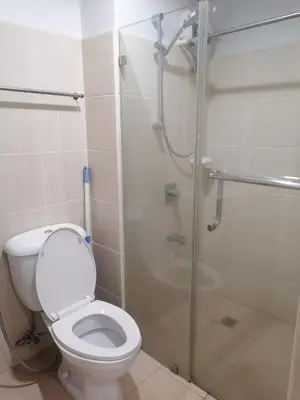 a bathroom with a toilet and a glass shower at SnugglePod Condotel - Grand Riviera Suites, US Embassy Manila, Roxas Blvd in Manila