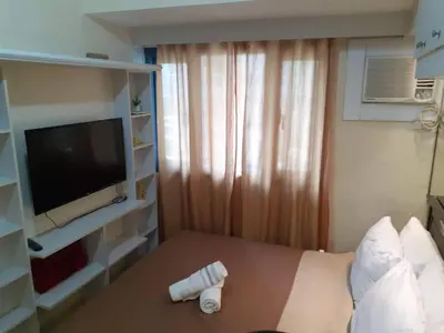 a hotel room with a bed and a television at SnugglePod Condotel - Grand Riviera Suites, US Embassy Manila, Roxas Blvd in Manila