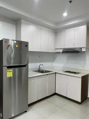 a kitchen with a stainless steel refrigerator and white cabinets at SnugglePod Condotel - Grand Riviera Suites, US Embassy Manila, Roxas Blvd in Manila