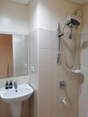a bathroom with a sink and a shower at SnugglePod Condotel - Grand Riviera Suites, US Embassy Manila, Roxas Blvd in Manila