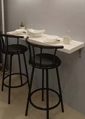 a table with two chairs and a white counter top at LIGHT HOUSE ( MOA STAYCATION) in Manila