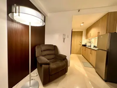 a living room with a chair and a refrigerator at Luxury Seaside Sunset View at SM Mall of Asia with free parking in Manila