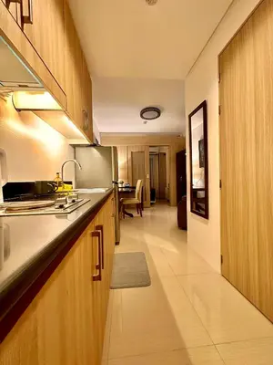 a kitchen with wooden cabinets and a stainless steel refrigerator at Luxury Seaside Sunset View at SM Mall of Asia with free parking in Manila