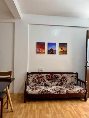a couch in a room with three paintings on the wall at Sebastians Crib in Dasmariñas