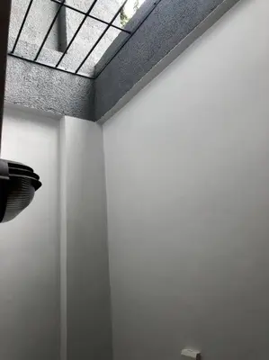 a room with white walls and a ceiling with a window at Sebastians Crib in Dasmariñas