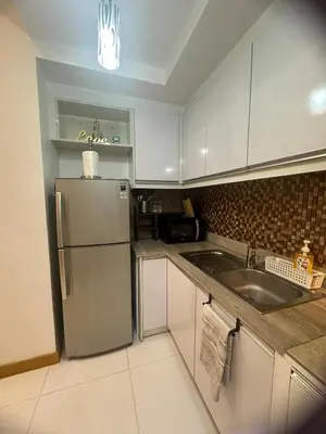 a kitchen with a refrigerator and a sink at Cozy Place with City View at Greenbelt Makati in Manila