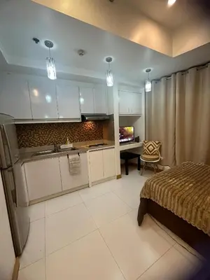 a kitchen and a bedroom with a bed and a desk at Cozy Place with City View at Greenbelt Makati in Manila