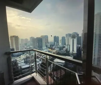 a view of a city from a balcony at Cozy Place with City View at Greenbelt Makati in Manila