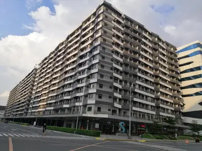 a large building with a person walking in front of it at S ResidencesTower 3 - L&R Staycation in Manila