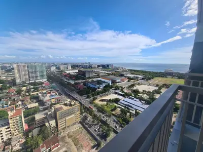 a view of a city from the balcony of a building at City and Sea view Staycation at Coast Residences in Manila
