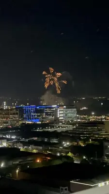 a city at night with a palm tree in the sky at City and Sea view Staycation at Coast Residences in Manila