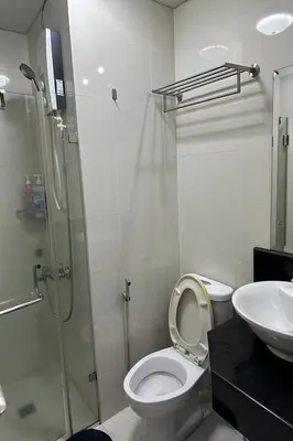 a bathroom with a shower and a toilet and a sink at Del's Condotel across NAIA Terminal 3 in Manila