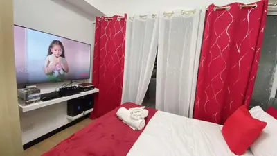 a bedroom with a bed with a tv in it at Azure south urban beach resort near airport in Manila