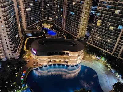 a large building with a pool in front of tall buildings at Azure south urban beach resort near airport in Manila