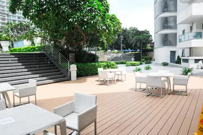 a patio with white tables and chairs and stairs at Azure south urban beach resort near airport in Manila