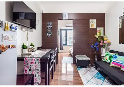 a kitchen and living room with a table and chairs at Marivic's Place at Air Residences Makati in Manila
