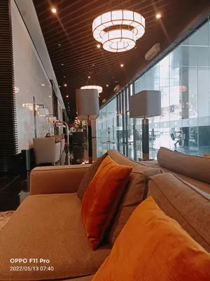a living room with a couch and a chandelier at Marivic's Place at Air Residences Makati in Manila