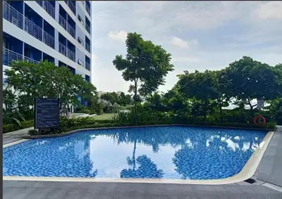 a large swimming pool in front of a building at Marivic's Place at Air Residences Makati in Manila