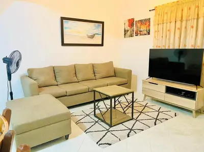 a living room with a couch and a flat screen tv at Awesome 2 bedrooms, living & dining area in General Trias