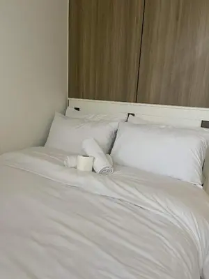 a white bed with two rolled towels on it at Staycation Mandaluyong Fame residences greenfield district by darpm in Manila