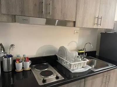 a kitchen with a sink and a dish rack on the counter at Staycation Mandaluyong Fame residences greenfield district by darpm in Manila