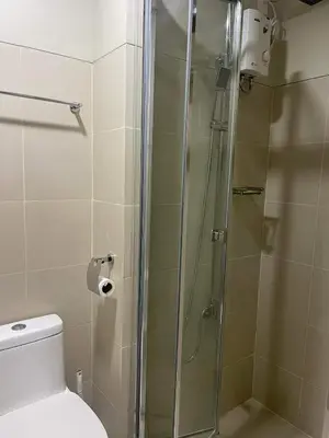 a bathroom with a glass shower with a toilet at Staycation Mandaluyong Fame residences greenfield district by darpm in Manila