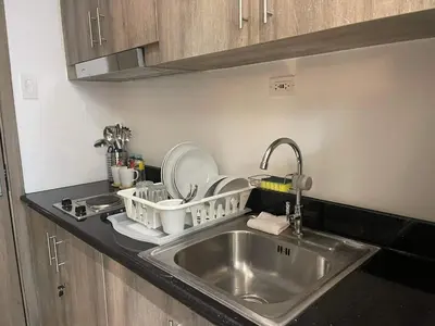 a kitchen sink with dishes in baskets on the counter at Staycation Mandaluyong Fame residences greenfield district by darpm in Manila
