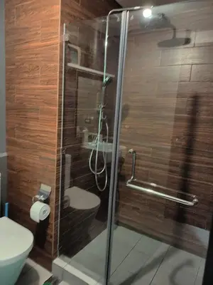 a glass shower in a bathroom with a toilet at Best Value Q Condo Radiance29S near Airport, Casinos, Star City, MOA, PICC, Harbour Square, Dolomite Beach in Manila